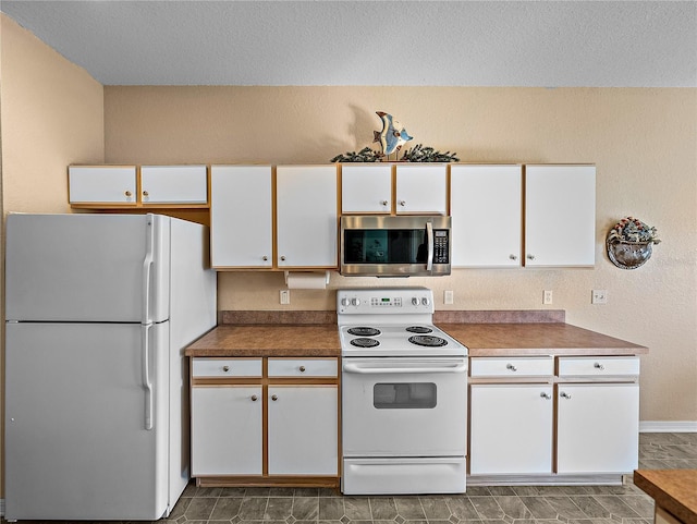 kitchen featuring white cabinetry, a textured ceiling, and white appliances