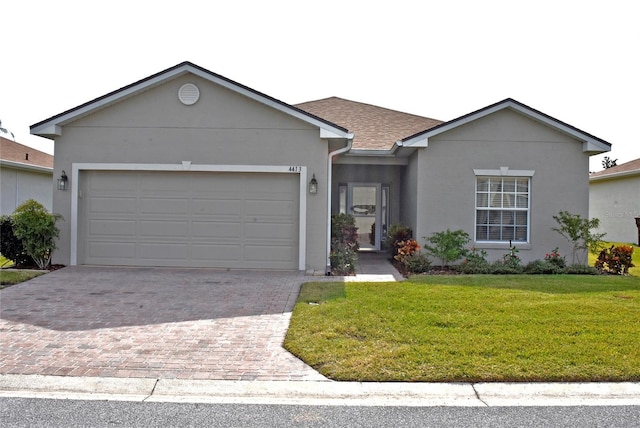 single story home with a garage and a front lawn