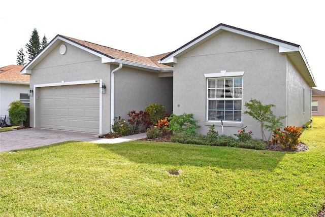 single story home with a garage and a front lawn