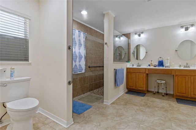 bathroom with a tile shower, tile patterned floors, vanity, and toilet