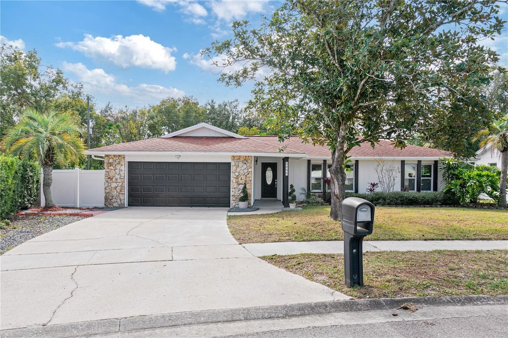 ranch-style home with a garage and a front lawn