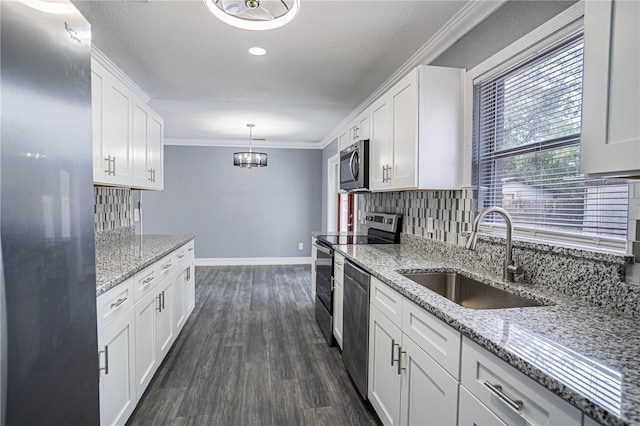 kitchen with stainless steel appliances, white cabinetry, sink, and hanging light fixtures