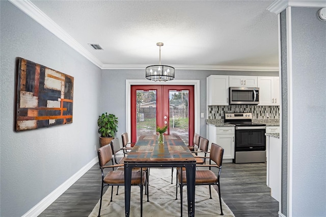 dining room with ornamental molding, french doors, dark wood-type flooring, and an inviting chandelier