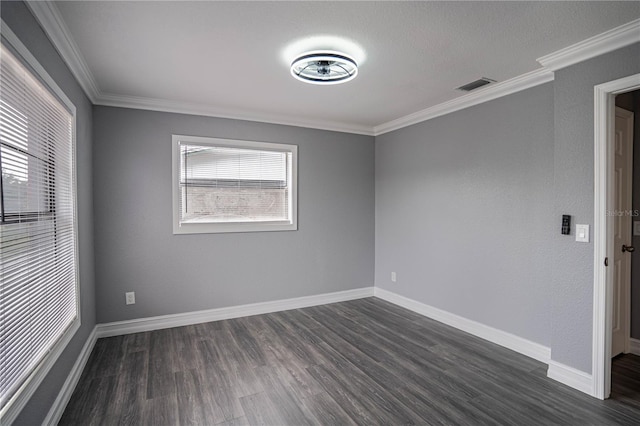 empty room featuring crown molding, a wealth of natural light, and dark wood-type flooring