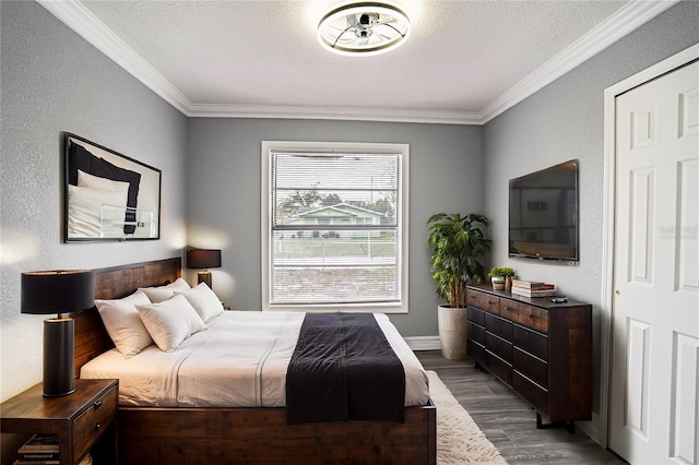 bedroom with a textured ceiling, dark hardwood / wood-style floors, and ornamental molding