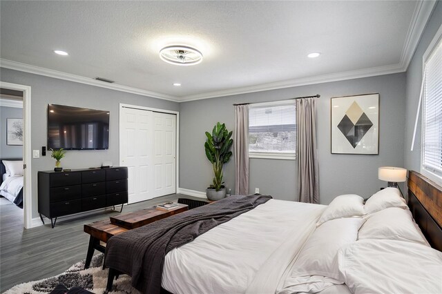 bedroom with wood-type flooring, a closet, and crown molding