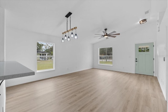 unfurnished living room with light hardwood / wood-style flooring, ceiling fan with notable chandelier, and lofted ceiling