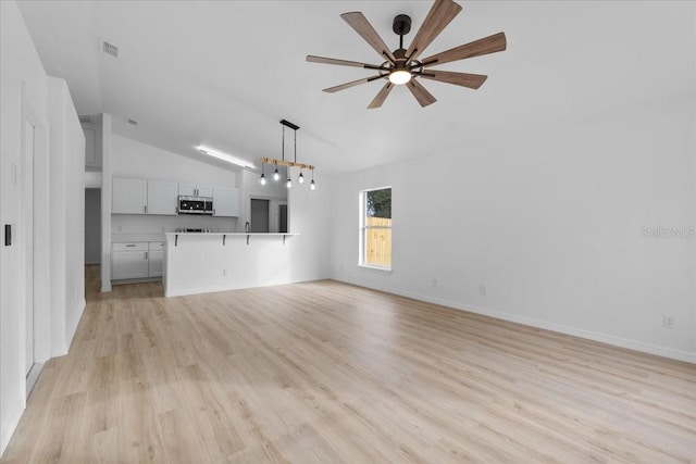 unfurnished living room with light wood-type flooring, ceiling fan, and lofted ceiling