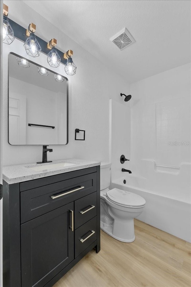 full bathroom featuring toilet, vanity, bathtub / shower combination, and hardwood / wood-style flooring