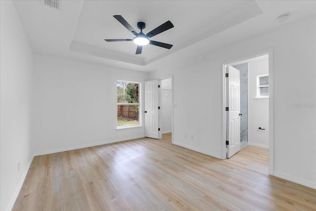 spare room featuring ceiling fan, a raised ceiling, and light hardwood / wood-style flooring