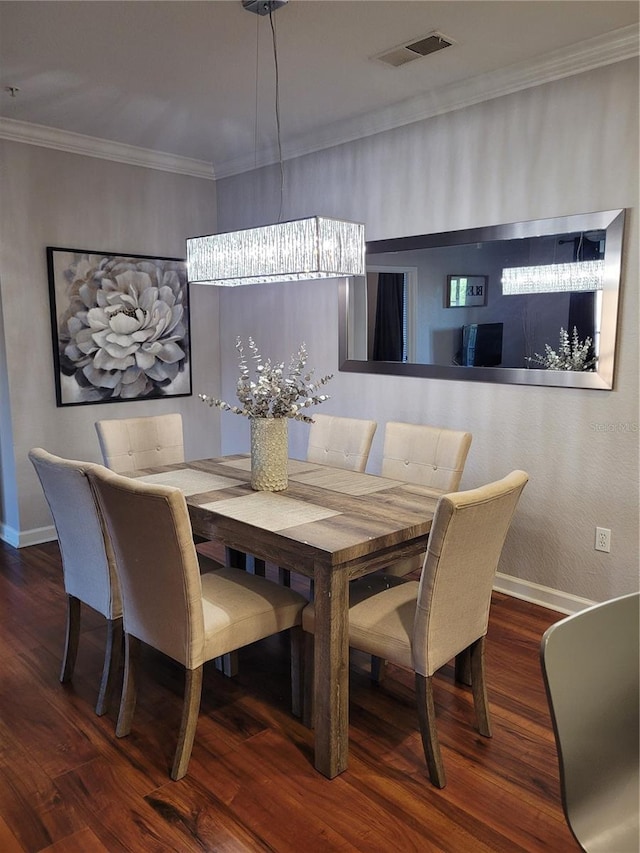 dining space featuring wood-type flooring, an inviting chandelier, and ornamental molding