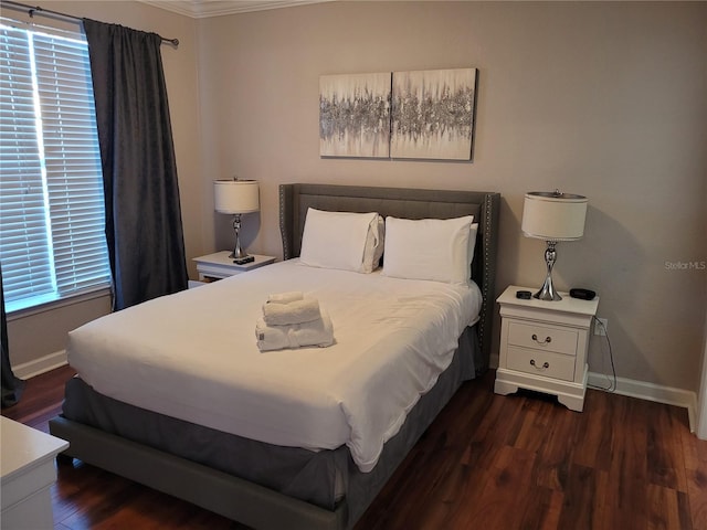 bedroom with dark hardwood / wood-style floors and ornamental molding