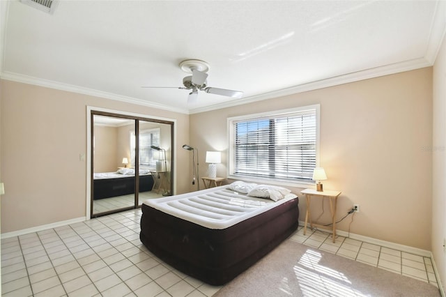 bedroom with ceiling fan, light tile patterned floors, crown molding, and a closet