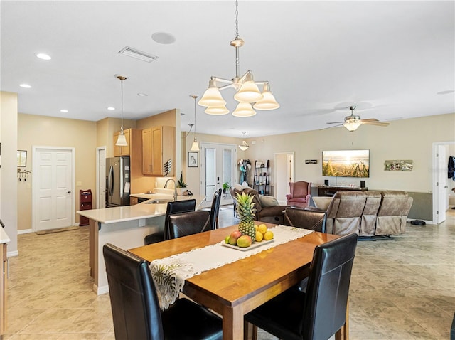 dining area with ceiling fan with notable chandelier, sink, and french doors