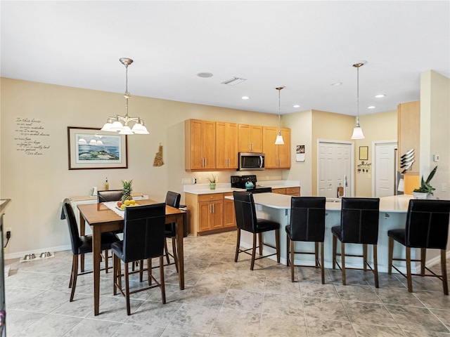 kitchen featuring a kitchen breakfast bar, range with electric stovetop, and hanging light fixtures