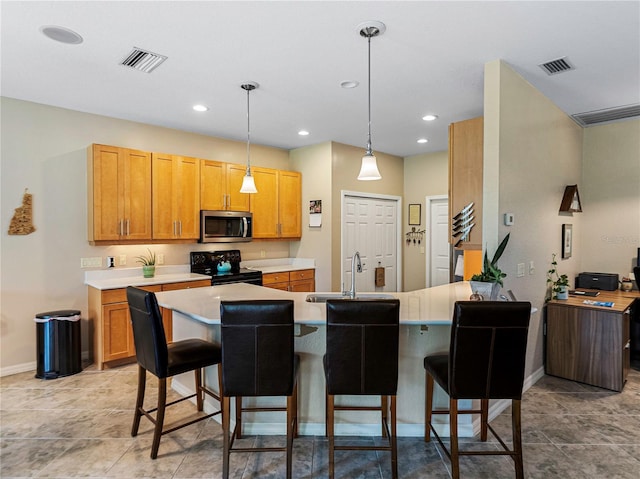 kitchen with black / electric stove, sink, pendant lighting, and a kitchen bar