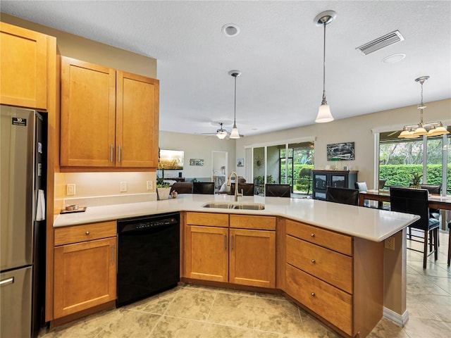 kitchen featuring kitchen peninsula, black dishwasher, decorative light fixtures, stainless steel refrigerator, and sink