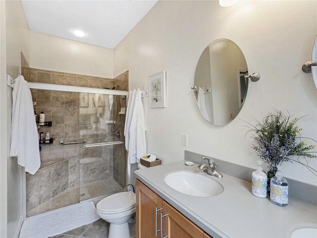 bathroom with toilet, vanity, a shower with door, and tile patterned floors