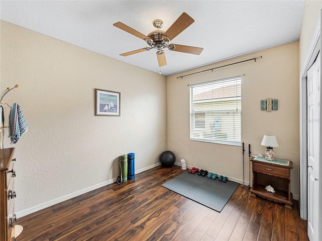 workout area with ceiling fan and dark hardwood / wood-style floors