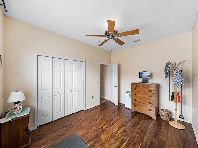 bedroom featuring ceiling fan, dark hardwood / wood-style flooring, and a closet