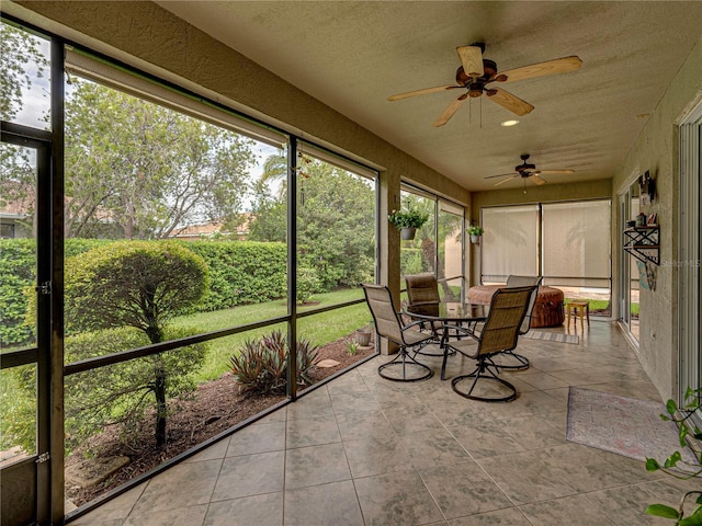 unfurnished sunroom featuring ceiling fan