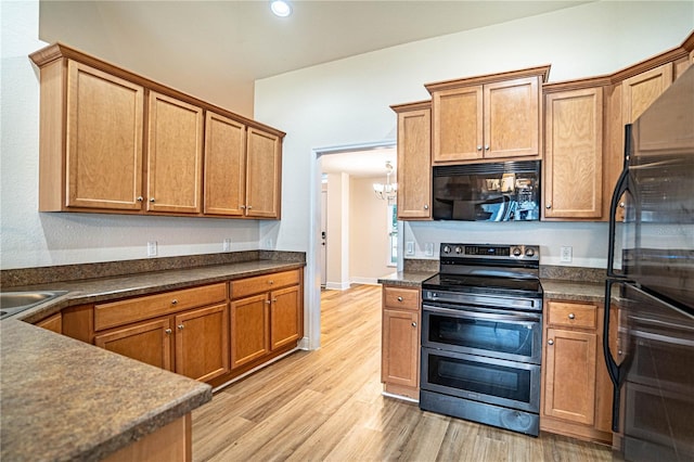 kitchen with an inviting chandelier, appliances with stainless steel finishes, and light hardwood / wood-style floors