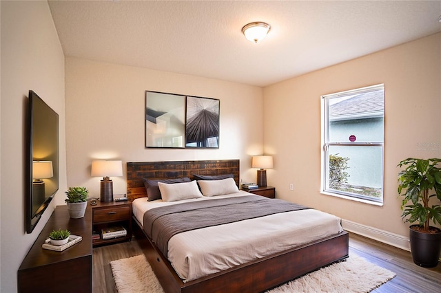 bedroom with dark hardwood / wood-style floors