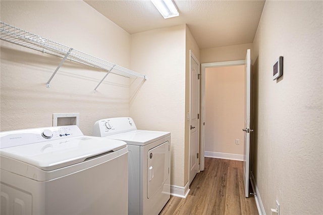 laundry area featuring washing machine and clothes dryer and light wood-type flooring