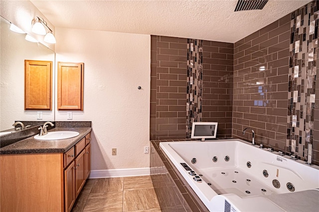 bathroom featuring vanity, tiled bath, and a textured ceiling