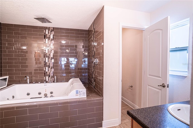 bathroom featuring hardwood / wood-style flooring, vanity, a relaxing tiled tub, and a textured ceiling