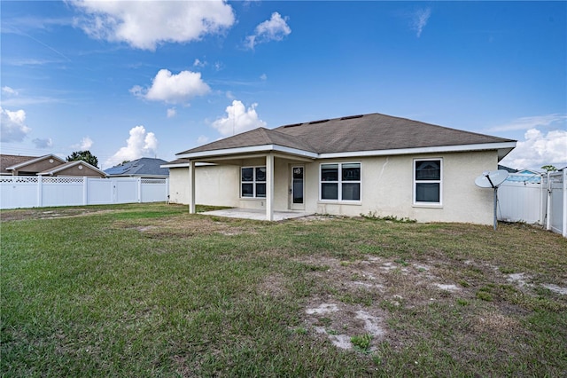 rear view of house featuring a yard and a patio