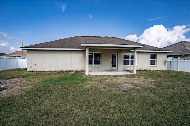 rear view of house with a patio and a yard