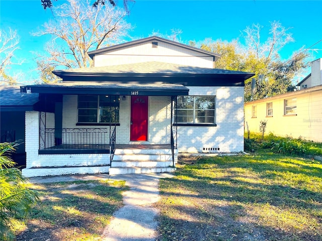 bungalow with covered porch and a front yard