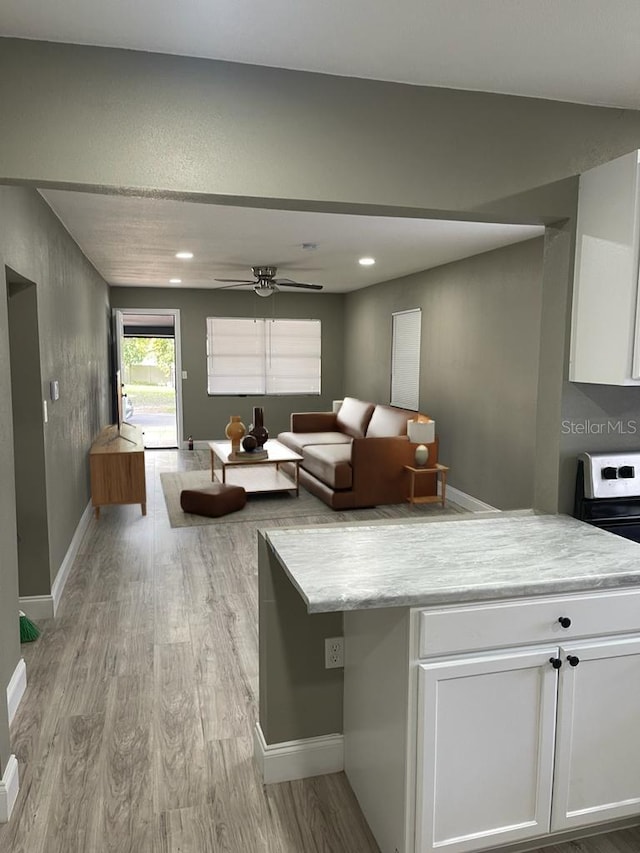 unfurnished living room featuring light wood-type flooring and ceiling fan