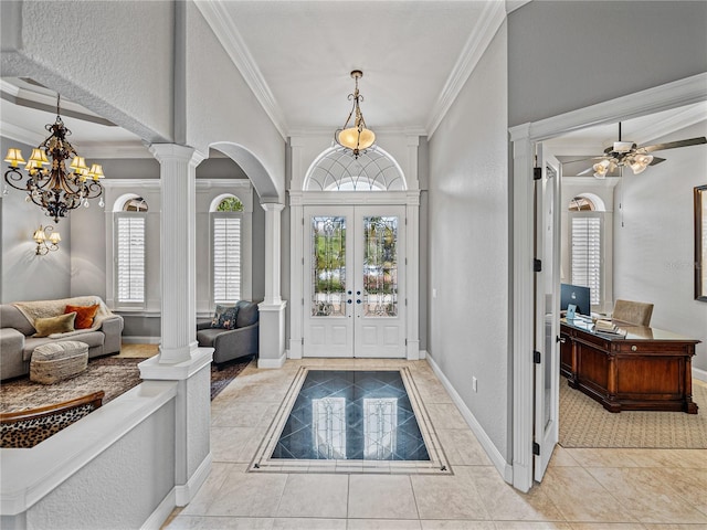 entryway featuring ornate columns, crown molding, a wealth of natural light, and light tile patterned flooring