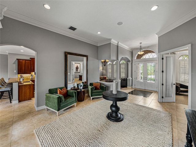 tiled entrance foyer with french doors, ornamental molding, and sink