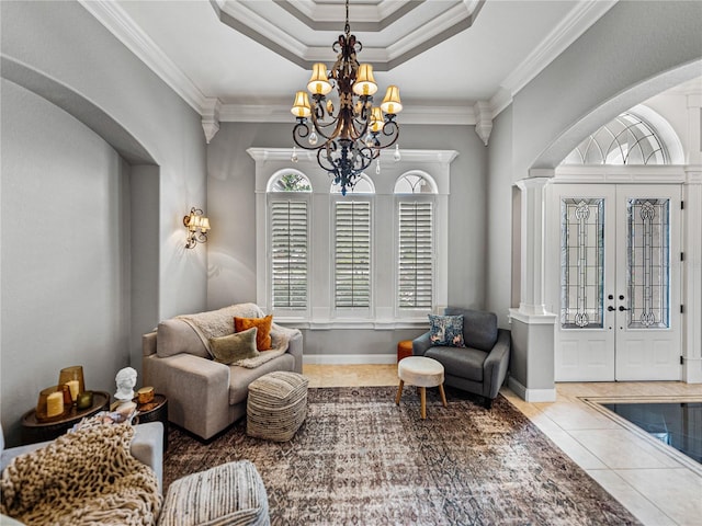 living area with ornamental molding, light tile patterned floors, a notable chandelier, a raised ceiling, and french doors