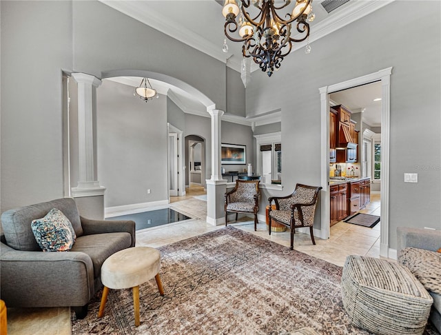 tiled living room featuring ornate columns and ornamental molding