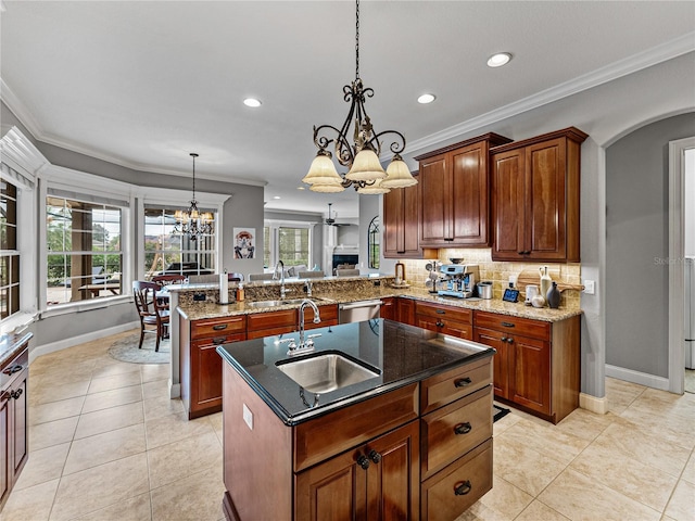 kitchen featuring sink, hanging light fixtures, a center island with sink, dishwasher, and kitchen peninsula