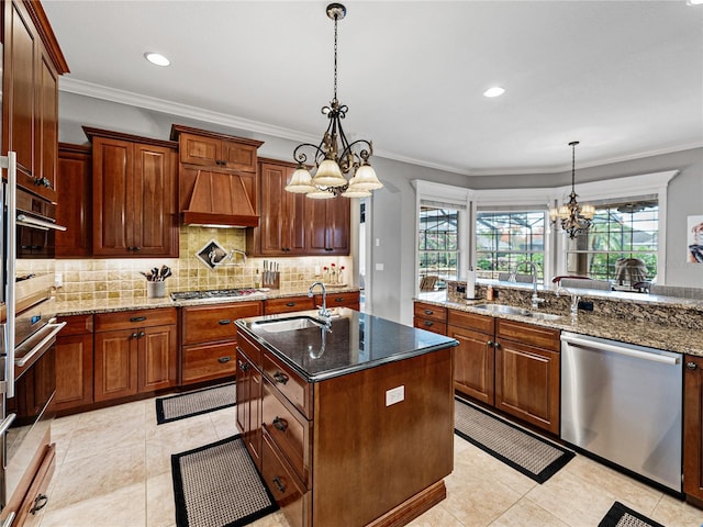 kitchen with sink, decorative light fixtures, stainless steel appliances, and a center island with sink