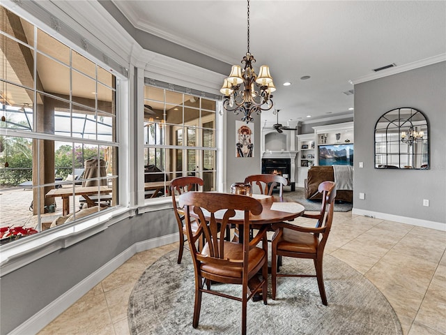 dining space with a warm lit fireplace, a notable chandelier, visible vents, and crown molding