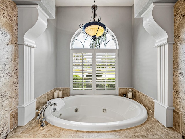 bathroom with a relaxing tiled tub and ornate columns