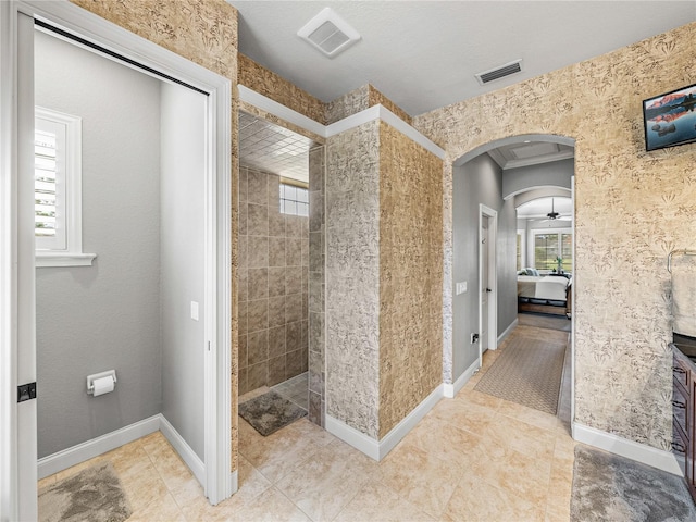 bathroom with tiled shower and tile patterned floors