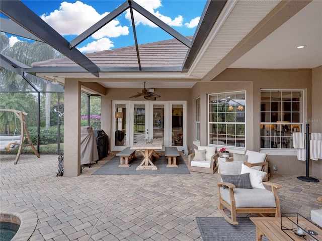 view of patio featuring french doors, grilling area, glass enclosure, ceiling fan, and an outdoor hangout area