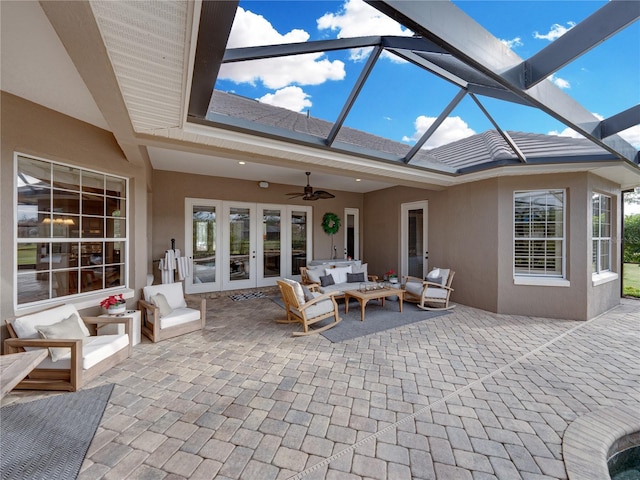 view of patio / terrace featuring an outdoor living space, french doors, ceiling fan, and glass enclosure