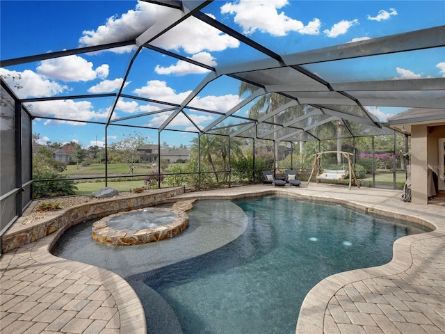 view of pool with an in ground hot tub, a patio, and glass enclosure