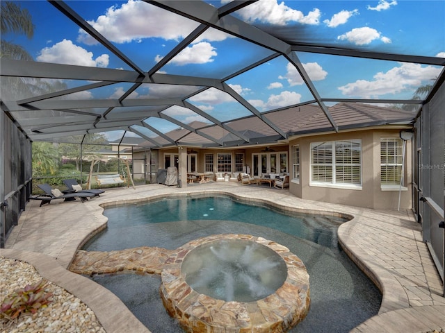 view of swimming pool with an in ground hot tub, ceiling fan, glass enclosure, and a patio