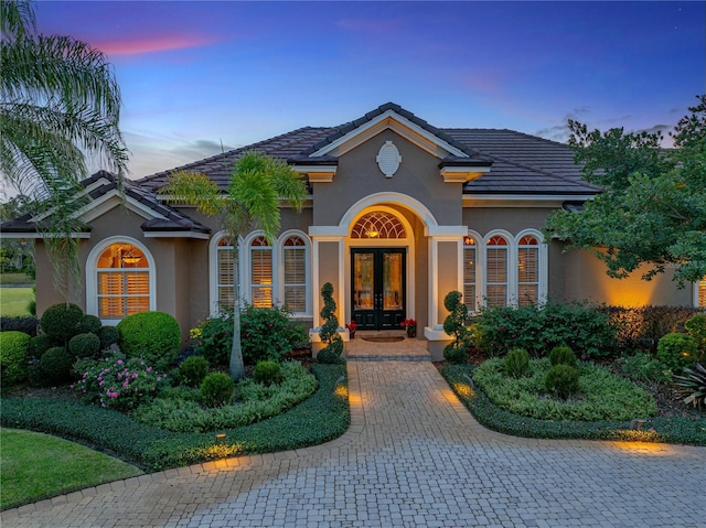 mediterranean / spanish home featuring french doors