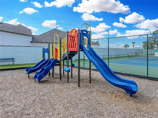 view of jungle gym featuring tennis court