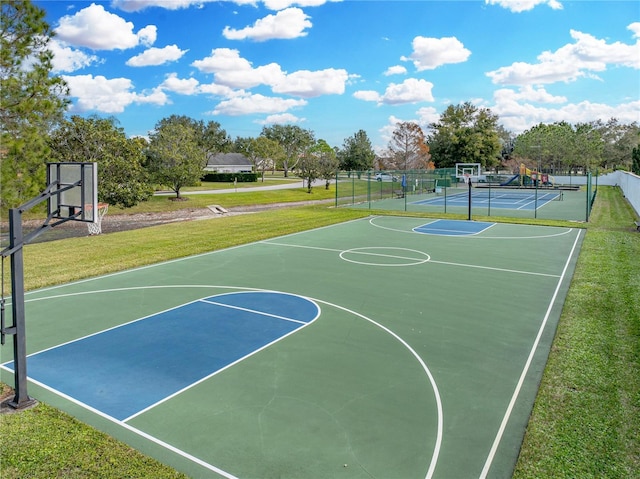 view of basketball court with a yard, community basketball court, and fence